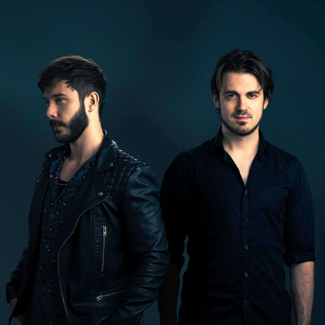 Vicetone posing together in black shirts green background