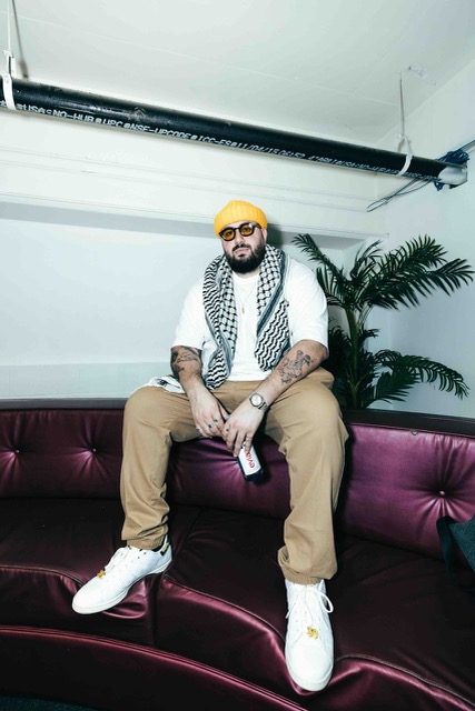 DJ HABIBEATS seated on a pruple comfy looking couch