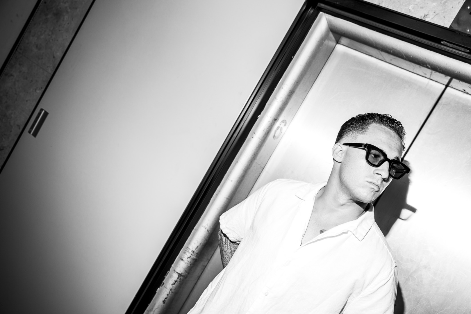 Black and white photo in a stair well stariing off into the distance