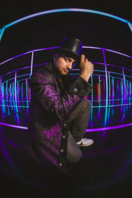 Wonka Willa posing with a top hat in a dark room