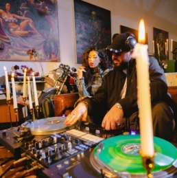 Felukah and DJ HABIBEATS sitting at his turn tables in a candle lit room