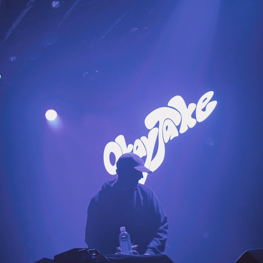 okay jake performing infront of a blue hue