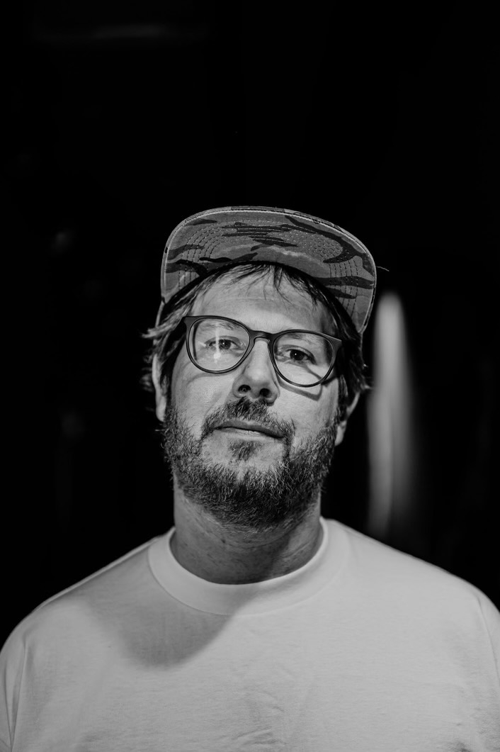 late night radiowearing a hat upon a black and wite background