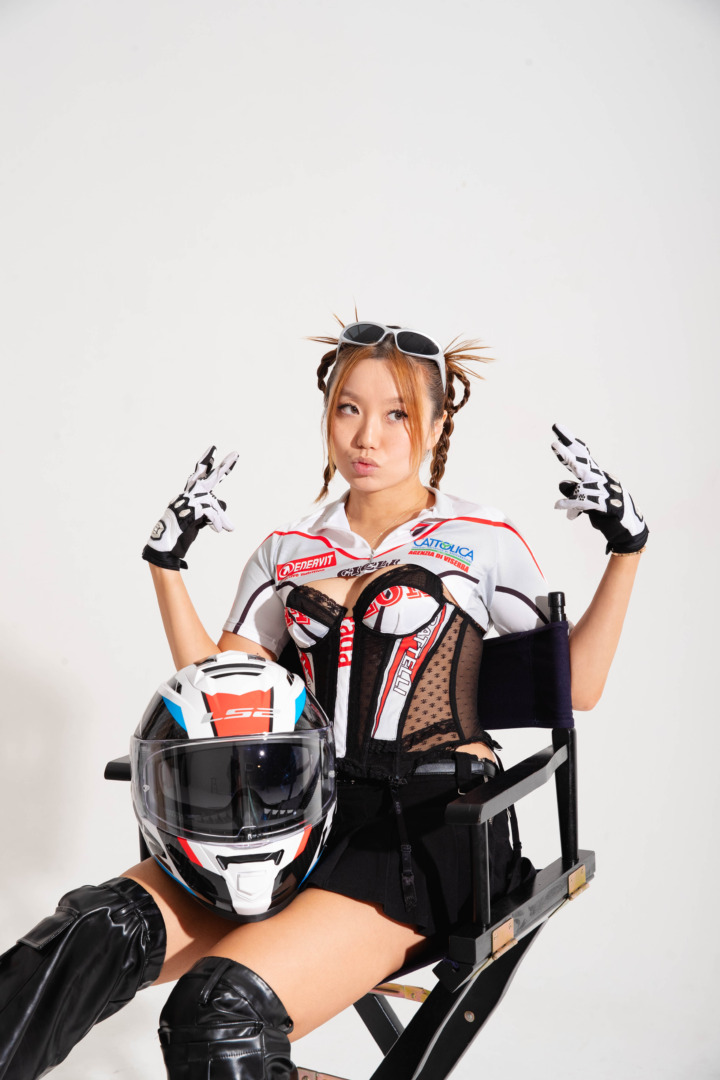 CHYL posing with a racing helmet and hands in the air