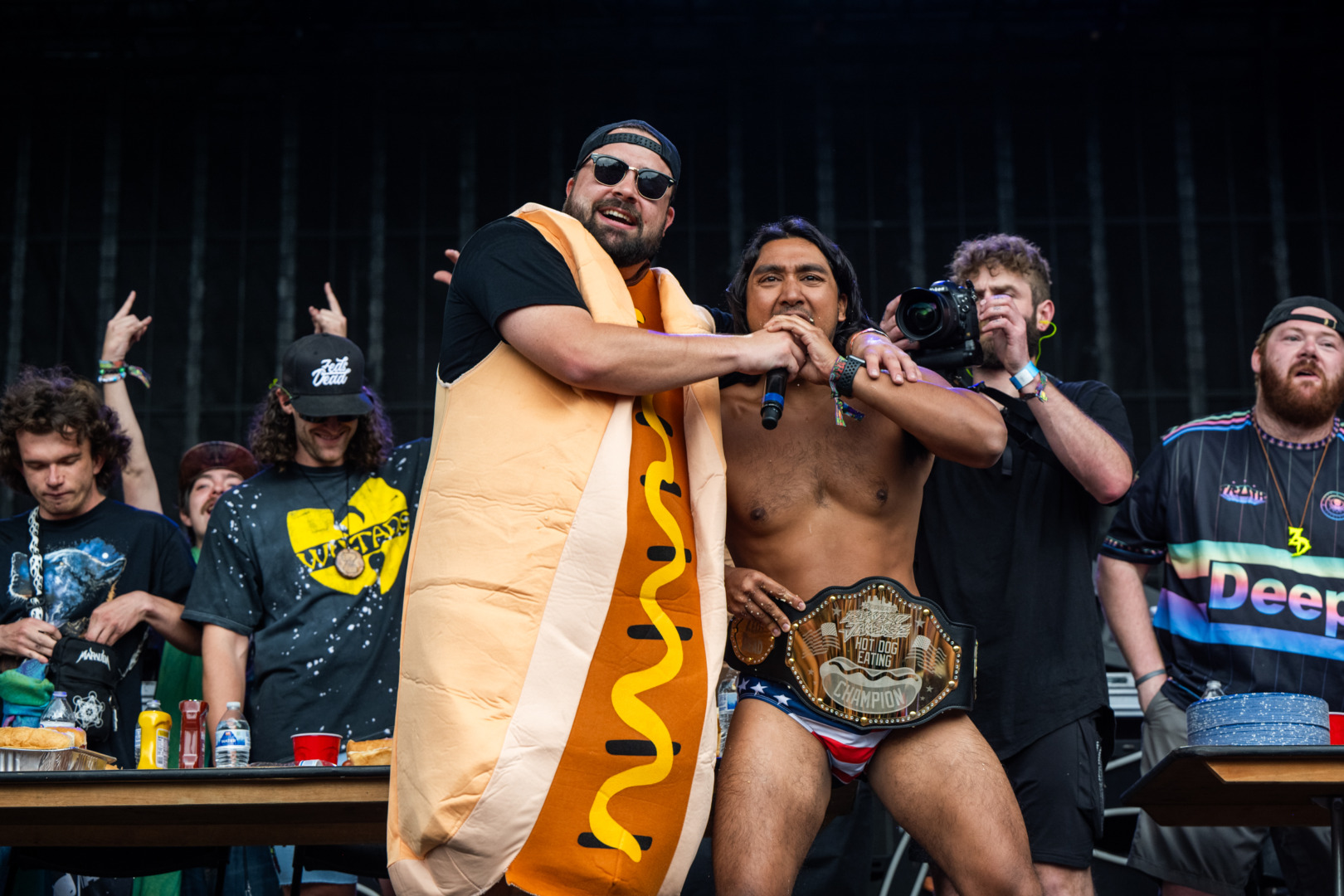 man in a hot dog suit award a belt to the winner!