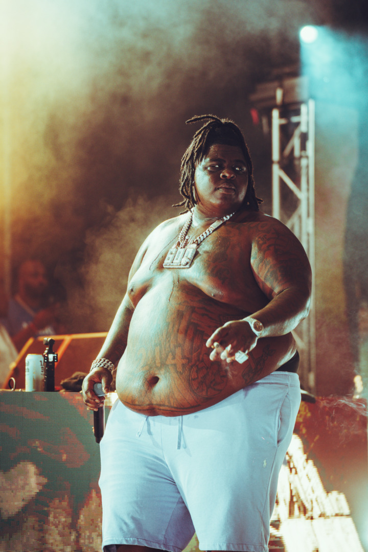 BigXThaPlug standing with the mic on stage upon a smokey background