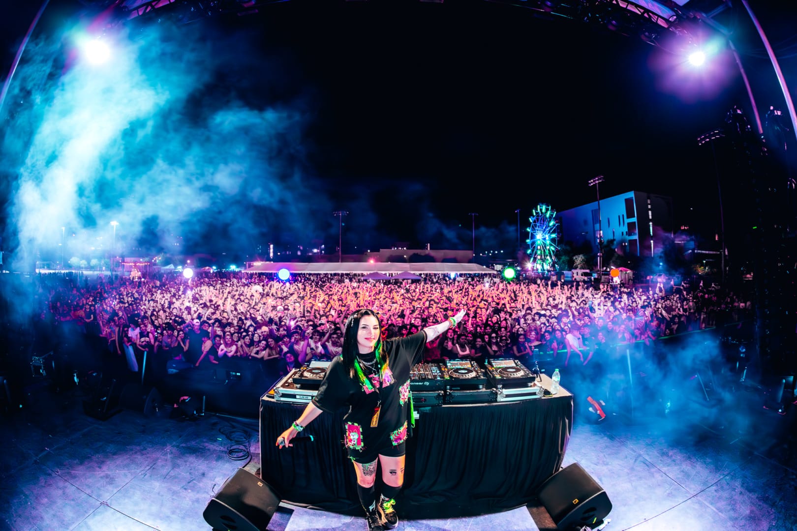 Green Matter posing infront of the decks with a sea of people behind her