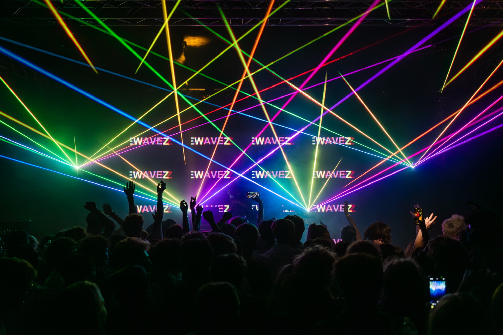 rainbow lasers over a darkened room