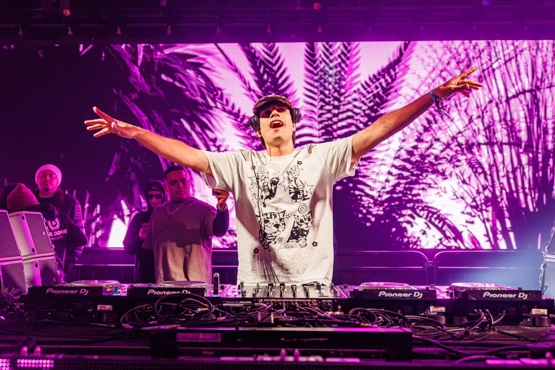 ODD MOB stretching his arms out wide upon a purple back ground